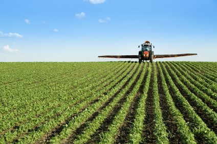 Tractor spraying soybean crop field